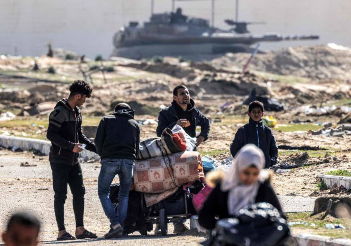 Varios ciudadanos palestinos frente a un carro de combate israelí (archivo)