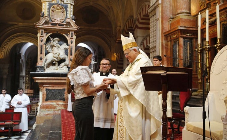 Imagen principal - Arriba, el obispo con una de las participantes, que aparecen debajo durante la misa. A la derecha, Demetrio Fernández abraza al sacerdote que irá a la misión