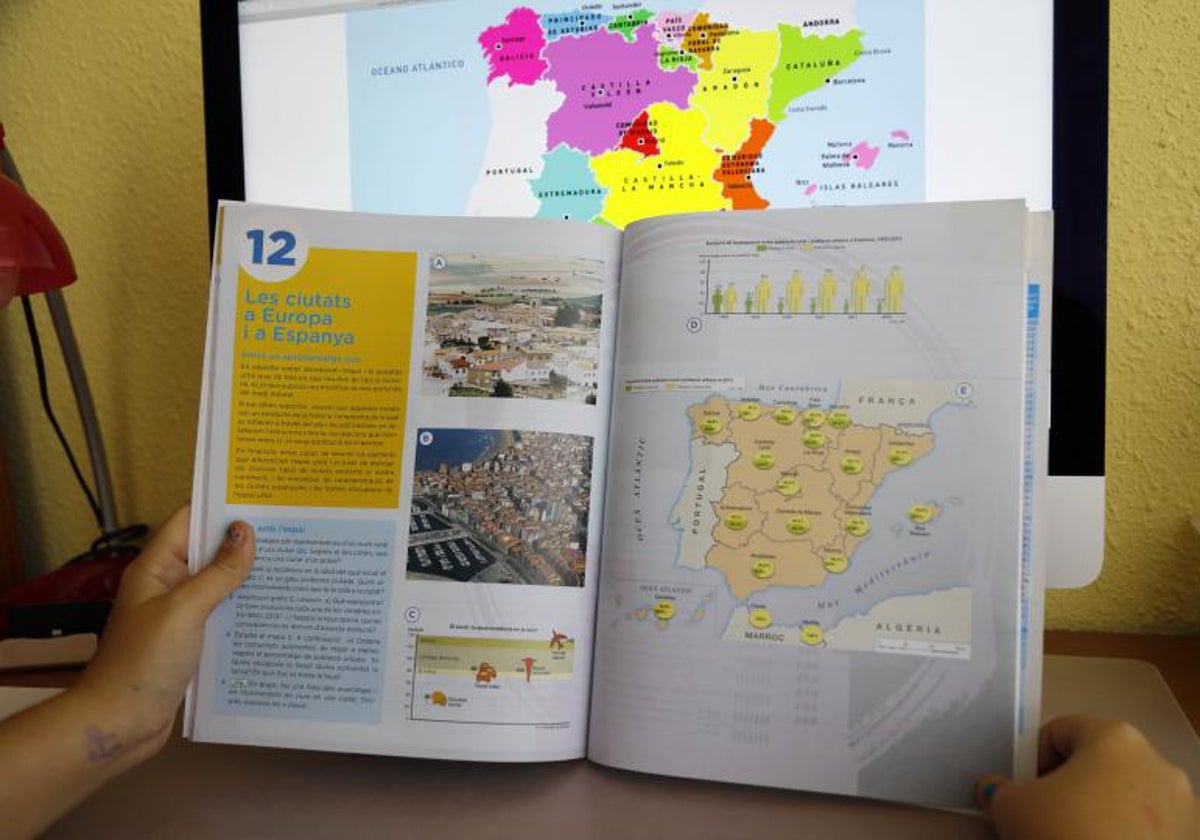 Un libro escolar de una materia troncal no lingüística en valenciano, en manos de una estudiante.
