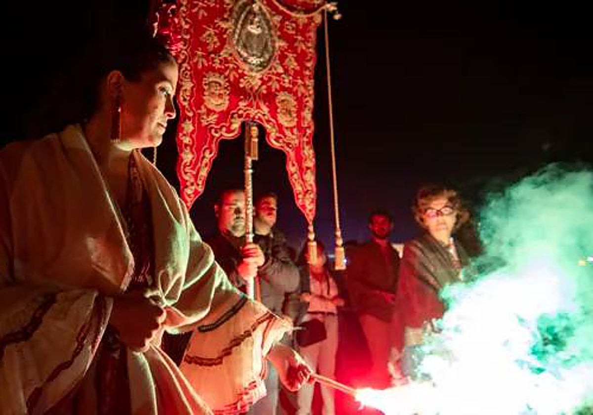 Simpecado de la hermandad de Huévar alumbrado por bengalas