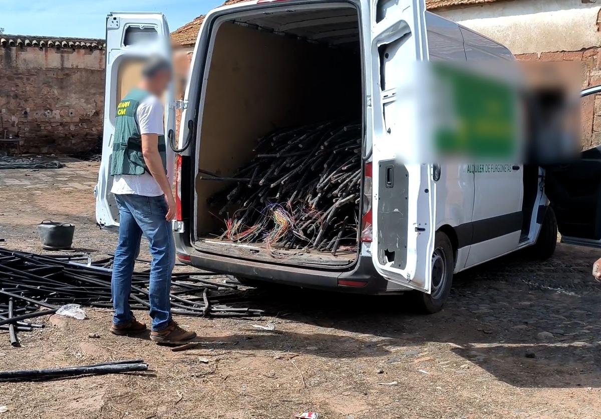 Un agente de la Guardia Civil ante una furgoneta cargada de cableado de cobre