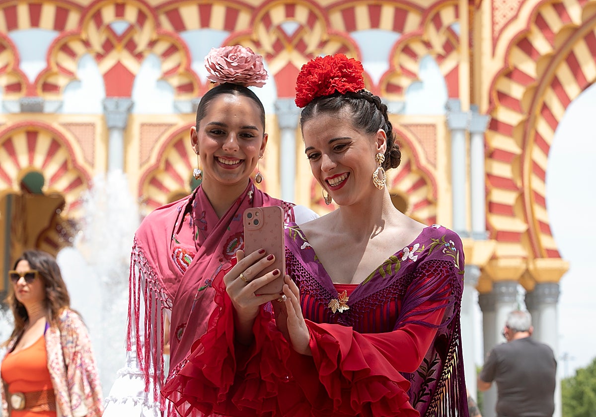 Dos jóvenes se hacen una foto delante de la portada