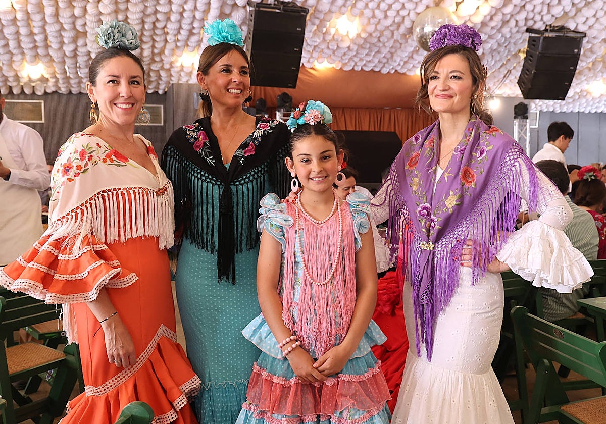 Unas mujeres y una niña posan en la despedida de la Feria en una caseta en el Arenal