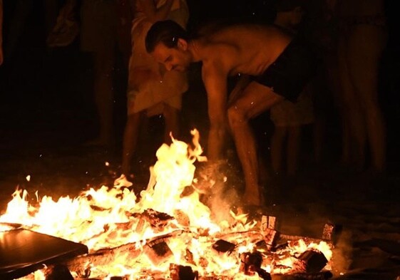 Imagen de una persona celebrando la noche de San Juan en la playa de Retamar, en Almería, alrededor de una hoguera