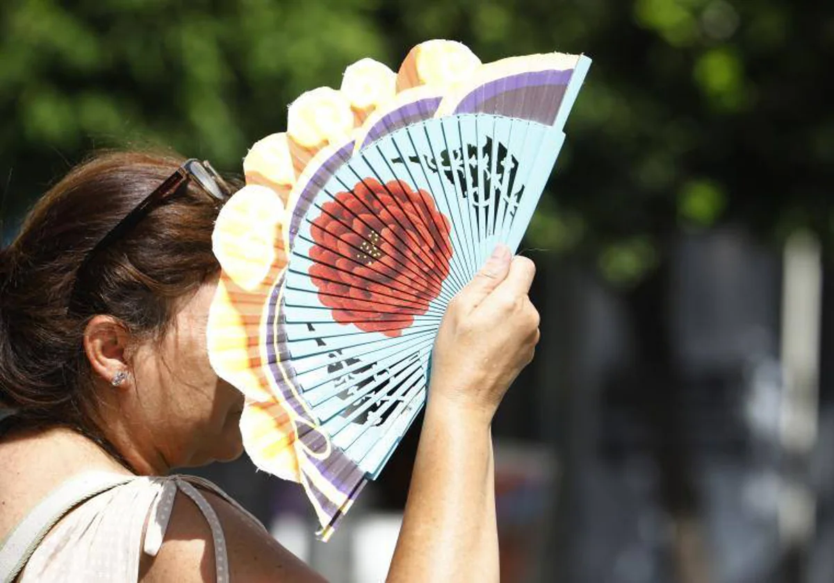 Una mujer se protege del sol con un abanico en Córdoba