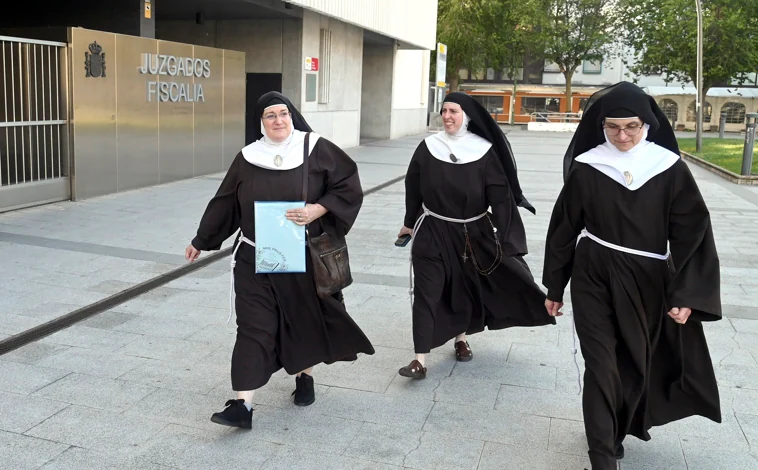 Imagen principal - Las clarisas de Belorado y José Ceacero, saliendo de los juzgados de Burgos. En la foto inferior, sorprendidas ante la presencia de fotógrafos, Sor Sión y Sor Paz dudan si salir del edificio. 