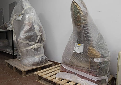 Imagen secundaria 1 - Obra embalada espera a ser trasladada a las sedes de la exposición. A la derecha, detalle de una intervención