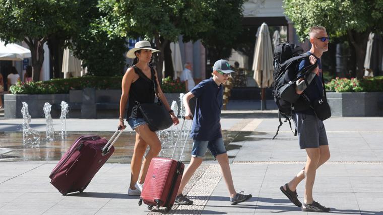 Una familia de turistas pasa por la plaza de las Tendillas