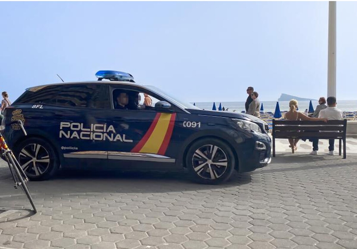 Un coche patrulla de la Policía Nacional circulando por el paseo de la Playa de Levante en Benidorm