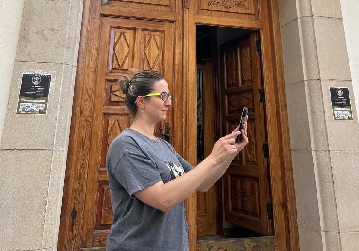 La alcaldesa de Catí (Castellón), Mamen Gámiz, prueba a utilizar su teléfono móvil en la puerta del Ayuntamiento.