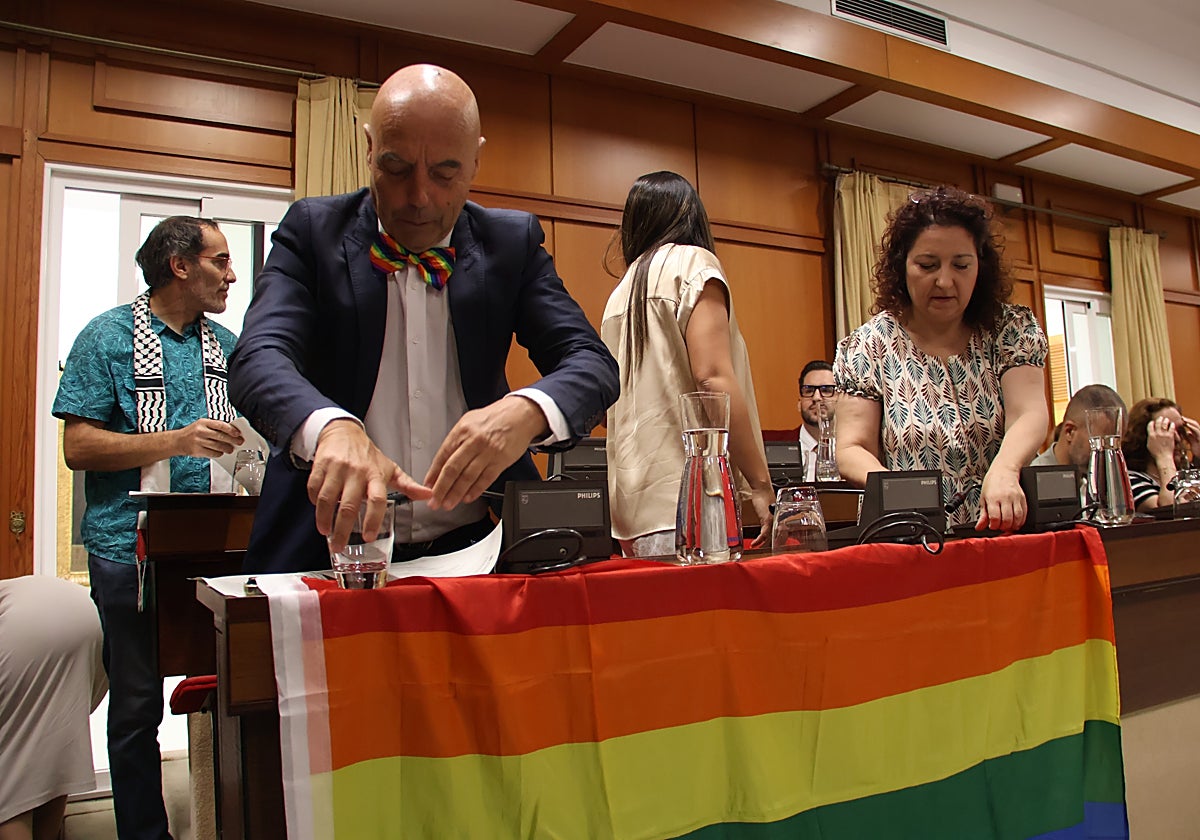 El portavoz socialista cuelga la bandera LGTBI en la bancada del PSOE en Capitulares