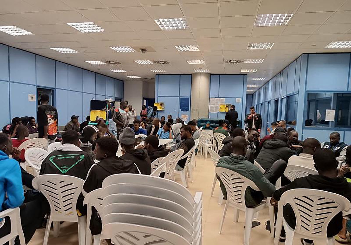 Imagen de archivo con decenas de inmigrantes esperando en una de las salas de asilo de Barajas