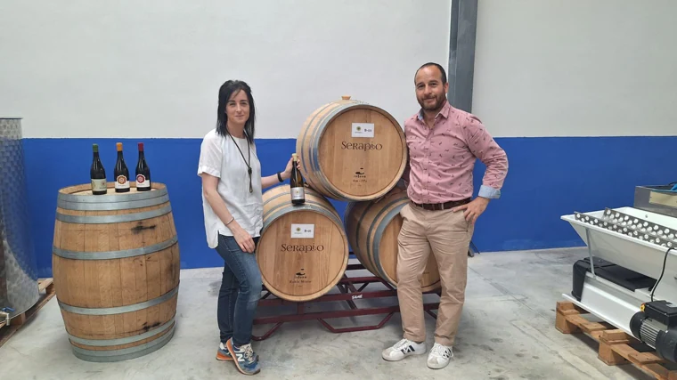 Patricia y José Ángel posan con las barricas de su pequeña bodega situada en Mota del Cuervo (Cuenca)