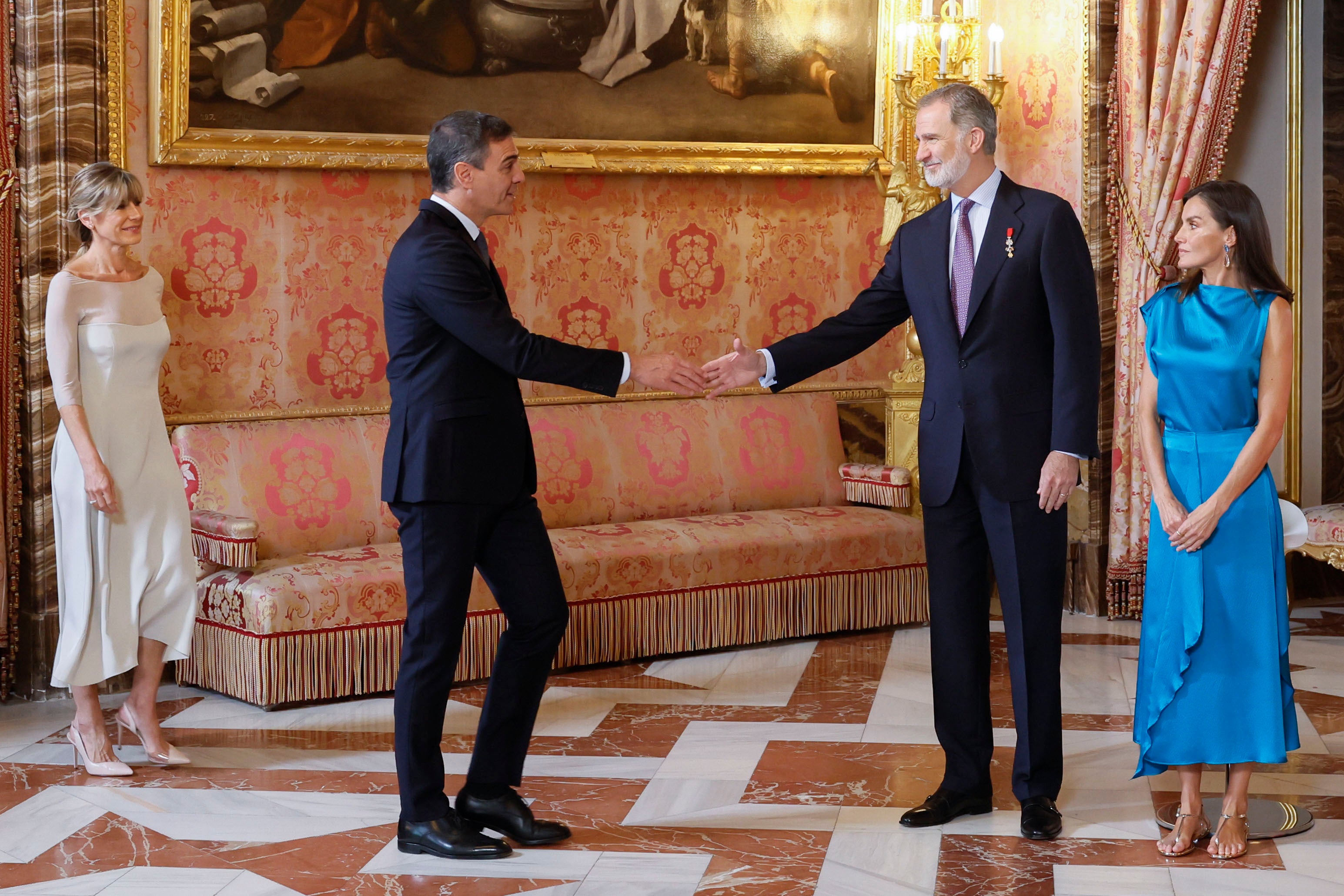 El Rey Felipe VI (2d) y la Reina Letizia (d) saludan al presidente del Gobierno, Pedro Sánchez (2i), y a su mujer Begoña Gómez (i) durante el besamanos en el Palacio Real.