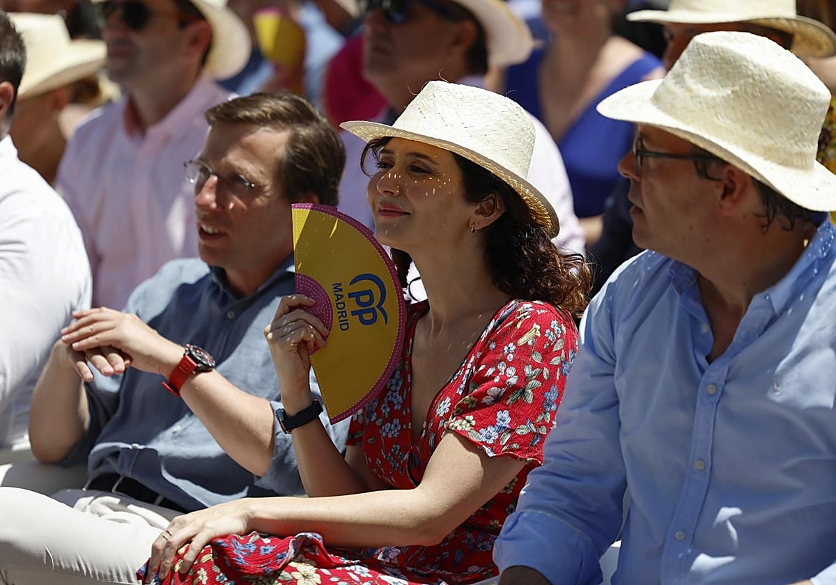 Isabel Díaz Ayuso, entre el alcalde y Alfonso Serrano, en la fiesta mitin del PP en Madrid