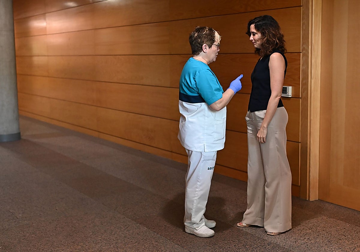 La presidenta Díaz Ayuso conversa con una trabajadora en la Asamblea de Madrid