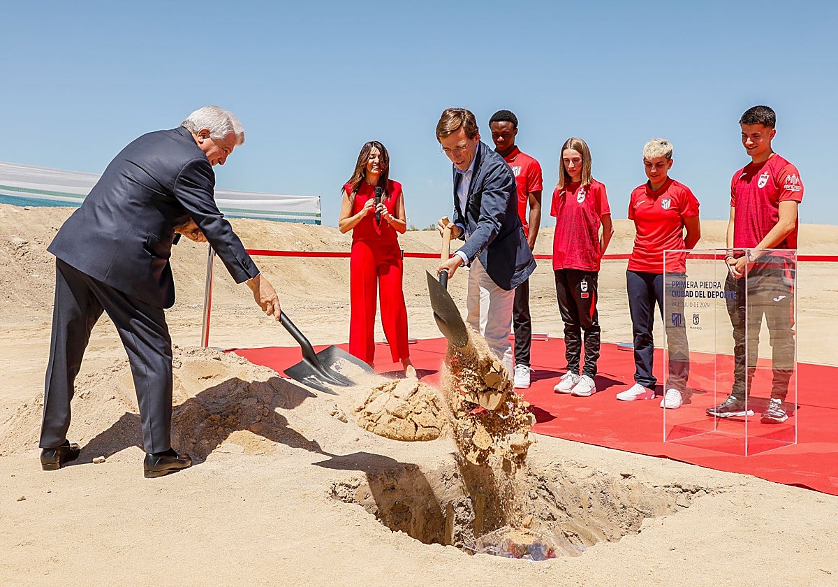 El presidente del Atlético de Madrid, Enrique Cerezo (izqda.), y el alcalde, José Luis Martínez-Almeida, entierran la urna como símbolo de la primera piedra de la Ciudad del Deporte