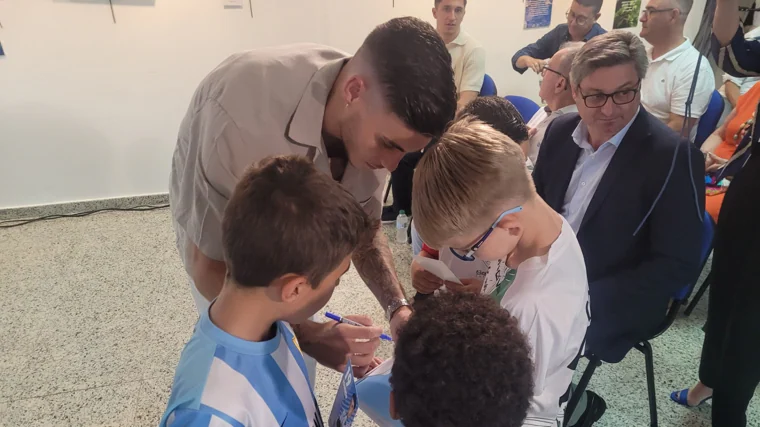 Roberto Fernández firmando las camisetas de los más pequeños