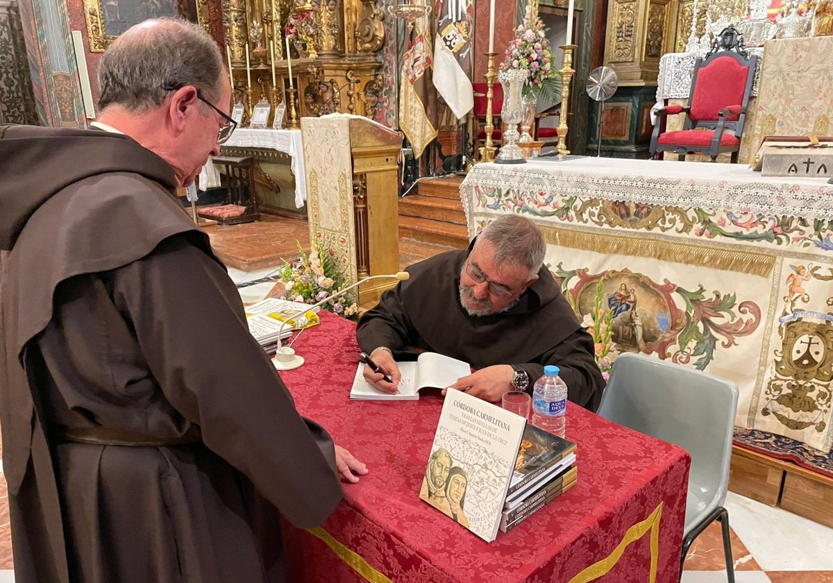 El padre Óscar Aparicio firma un ejemplar del libro al prior del convento de San Cayetano, el martes