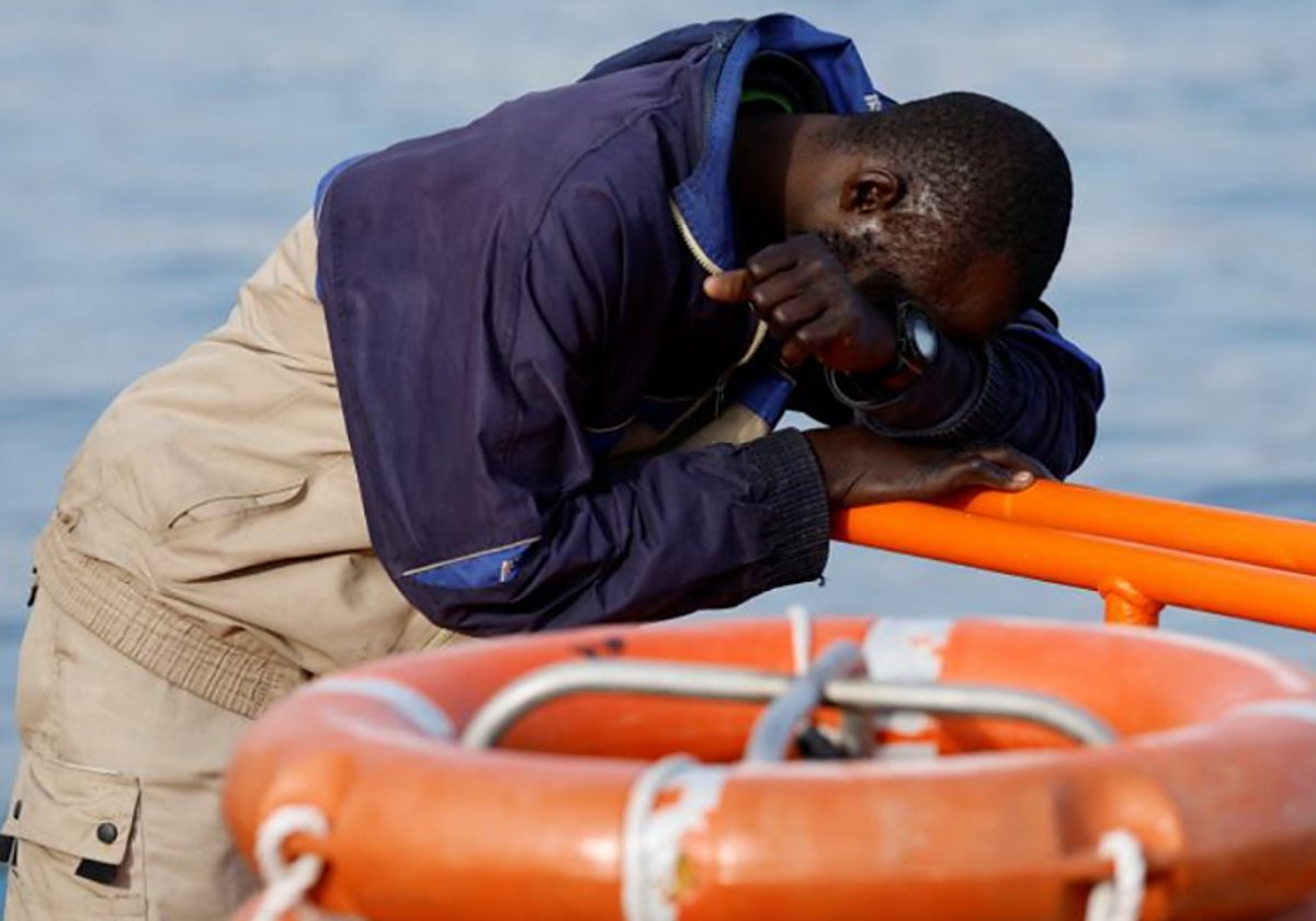 Un migrante se recupera de la travesía tras desembarcar en el muelle de Arguineguín en febrero