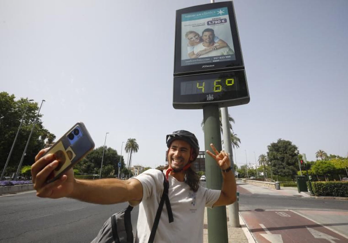 Un joven muestra el termómetro que marca 46 grados en la avenida de la Victoria en julio de 2023