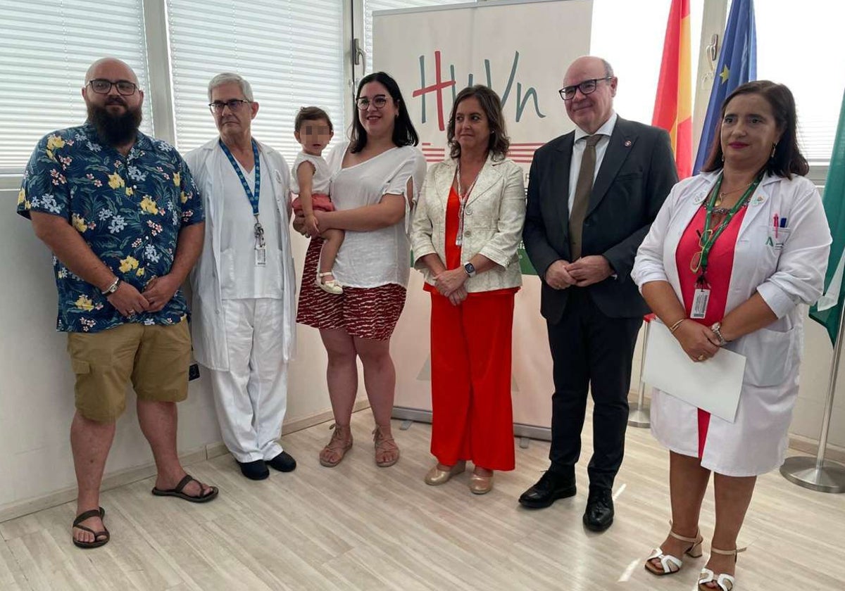 Nabila, en brazos de su madre, junto al doctor que la operó, el rector de la UGR y el padre de la niña, entre otros