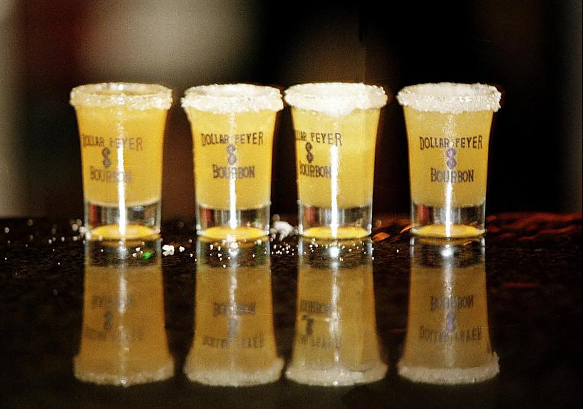 Unos chupitos de licor servidos en la barra de un bar