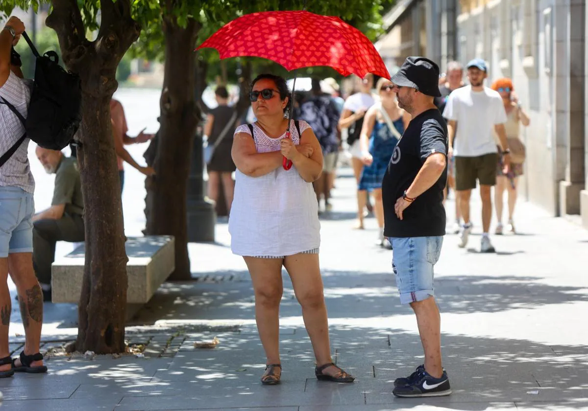 Turistas resguardándose del sol en el centro de Sevilla