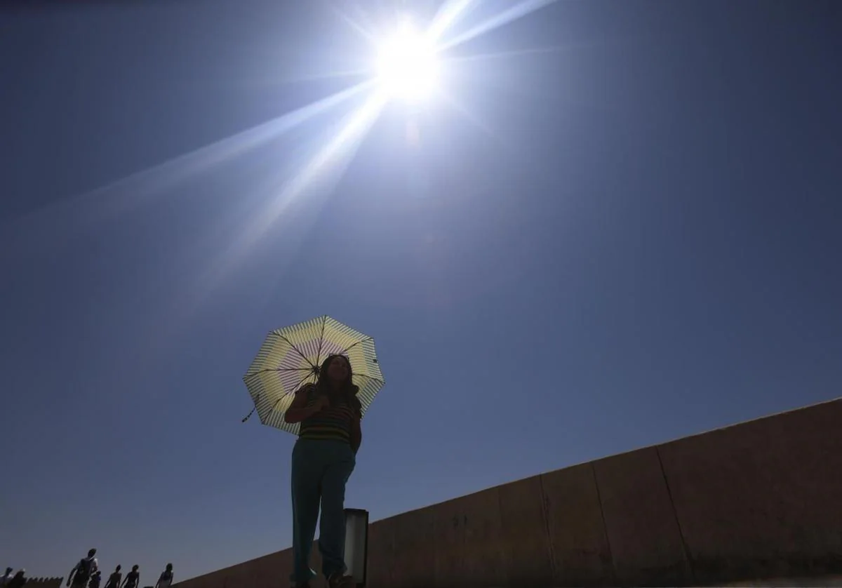 Una mujer de protege del calor en Córdoba