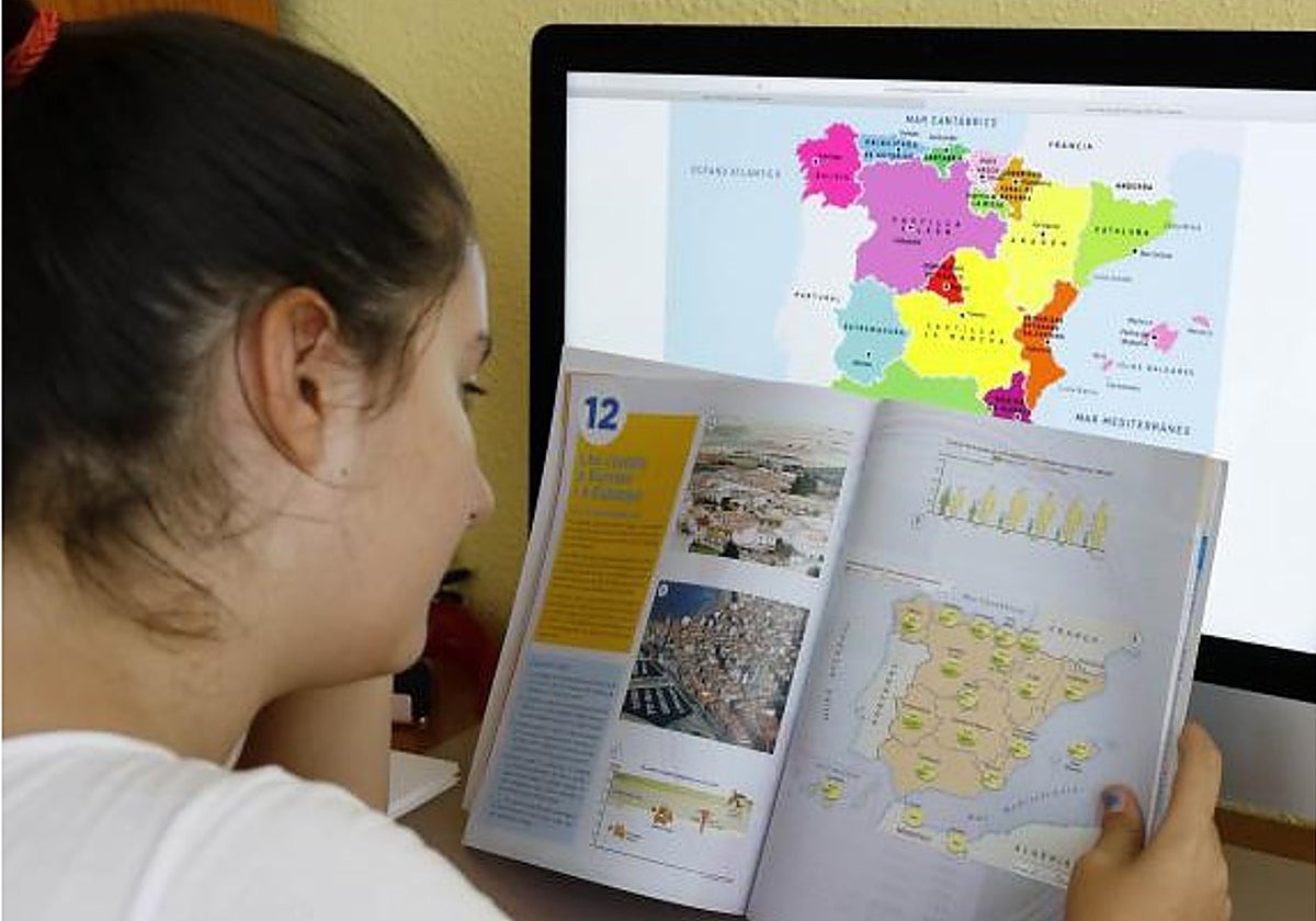 Una estudiante de Secundaria revisa un libro de texto en valenciano