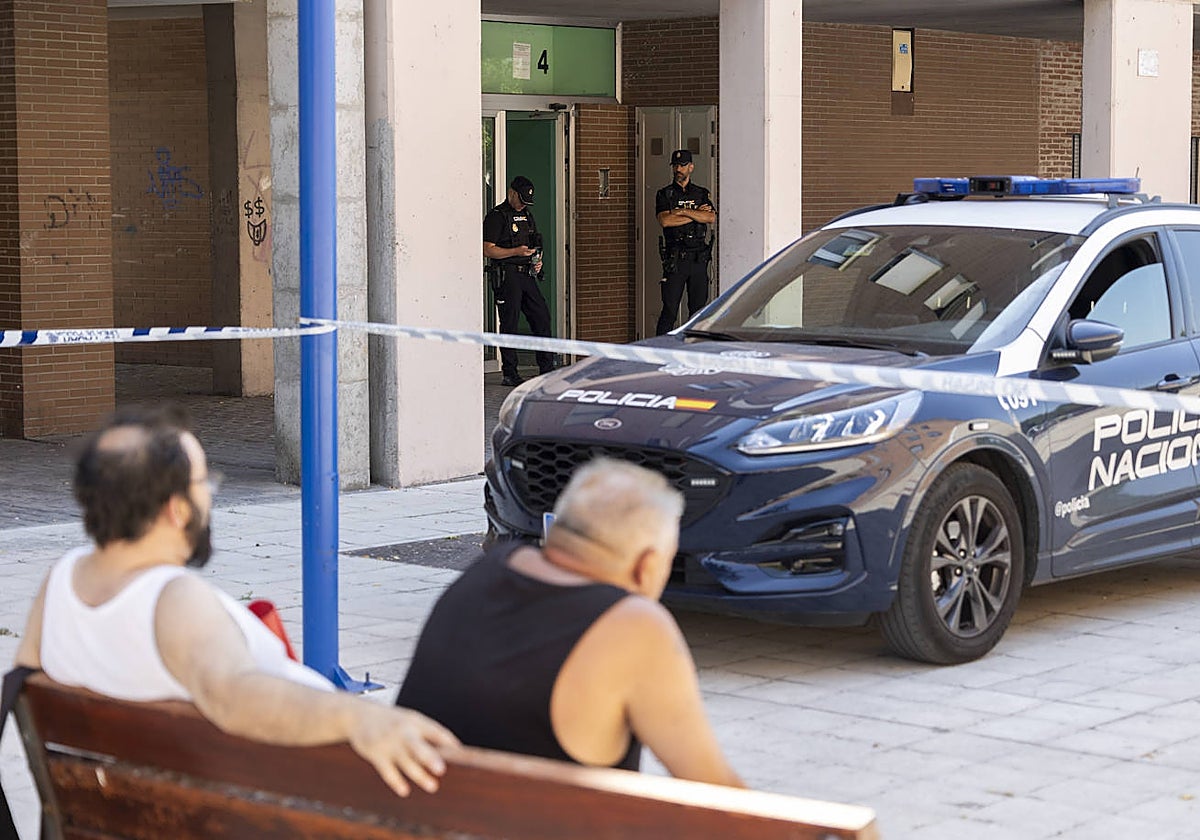 Vecinos observan la actuación de los efectivos de la Policía Nacional en el número 4 de la calle Sisón, donde fue hallada la mujer muerta