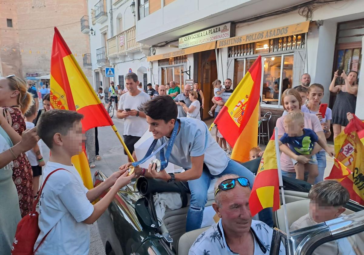 María Pérez muestra sus medallas a un niño durante el homenaje tributado el martes 13 de agosto en Orce