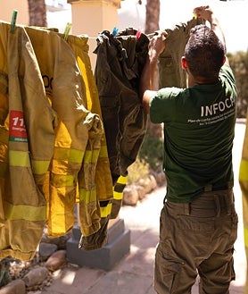 Imagen secundaria 2 - Parte de la brica 703 lleva avituallamiento a un retén que les da el relevo en Casares. Las brigadas siempre comen juntas y eso sirve para hacer equipo. Juan Umbría tiende la ropa en una de las treguas del fuego. 