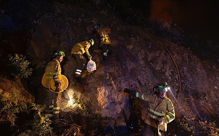 Imagen principal - Parte de la brica 703 lleva avituallamiento a un retén que les da el relevo en Casares. Las brigadas siempre comen juntas y eso sirve para hacer equipo. Juan Umbría tiende la ropa en una de las treguas del fuego. 