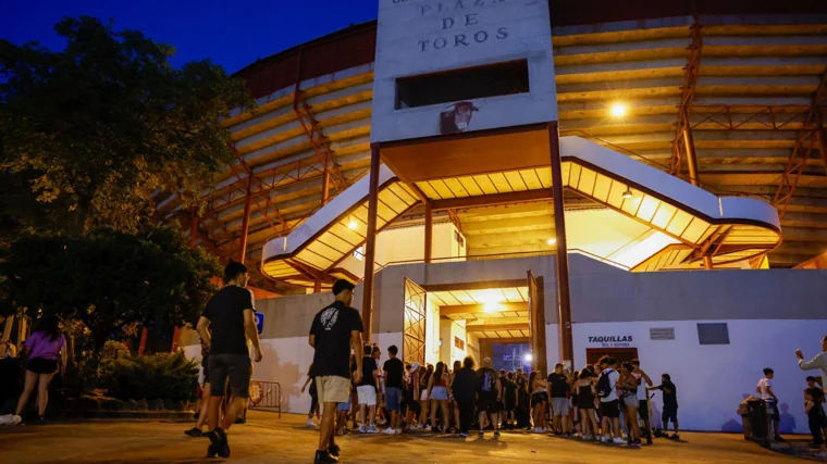 Unos jóvenes entrando a la plaza de toros de la localidad para disfrutar de música