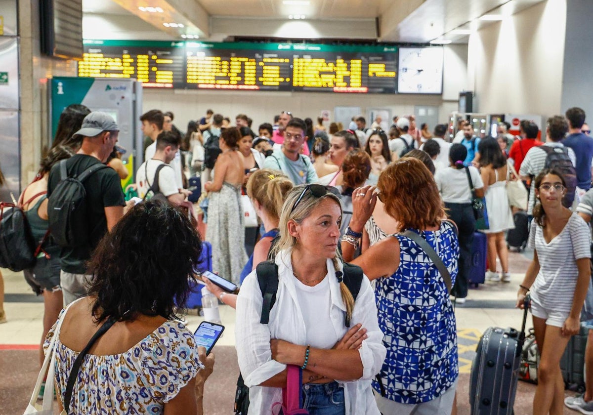 Viajeros esperan junto a sus maletas tras los retrasos de trenes en la estación de Chamartín, este martes