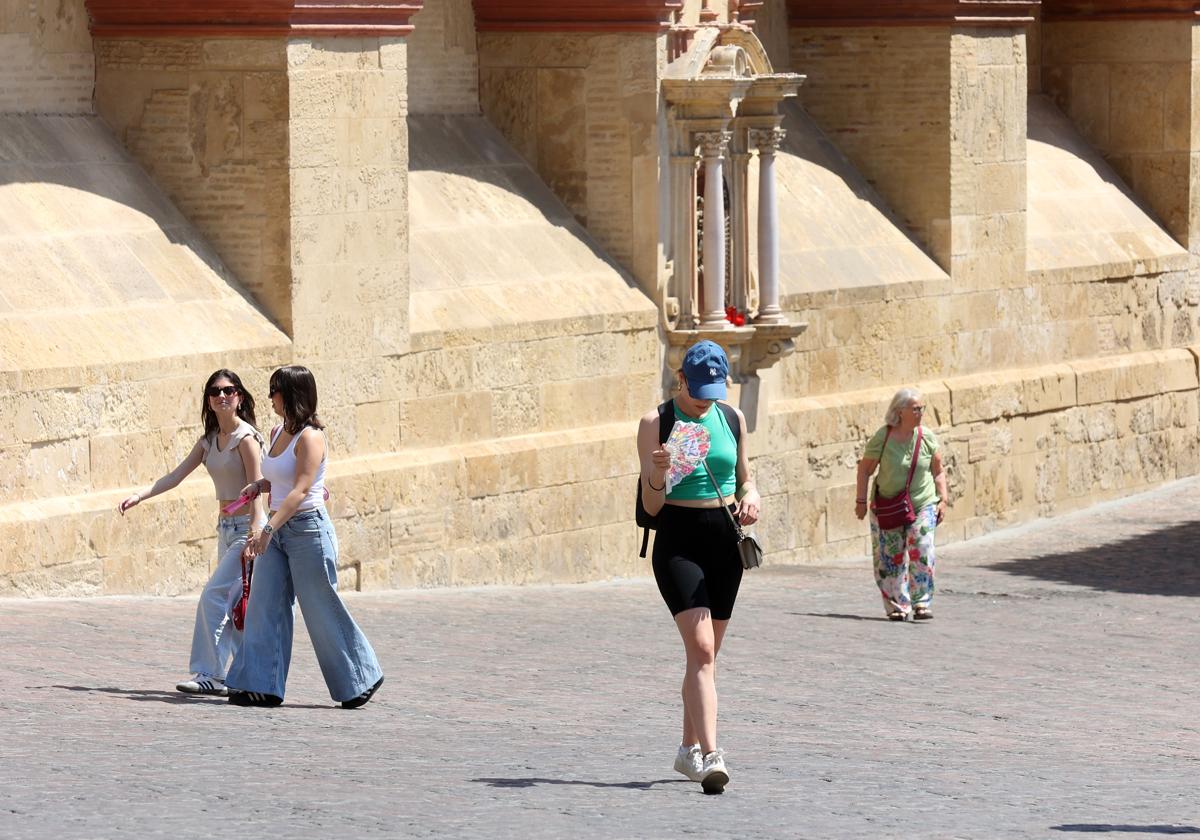 Una turista combate el calor con un abanico junto a la Mezquita-Catedral