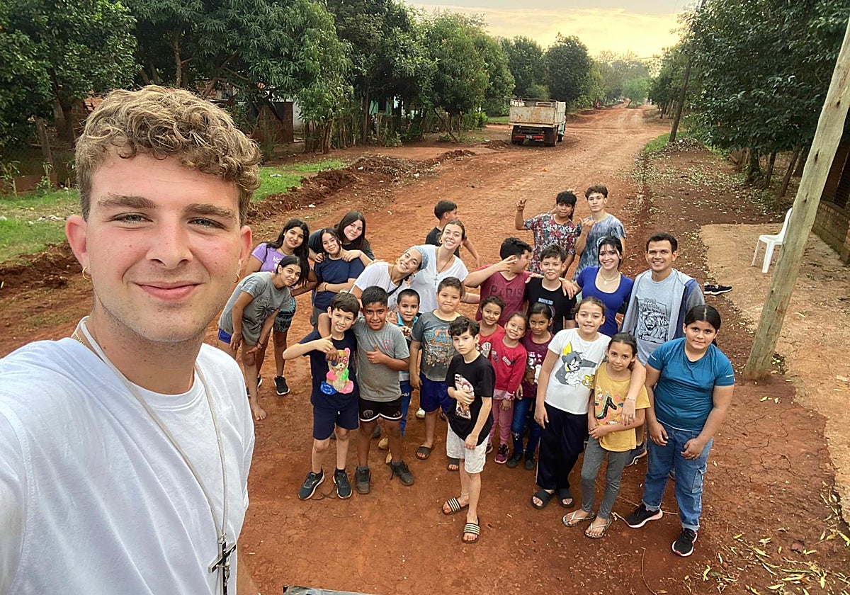 Jóvenes misioneros desplazados junto a un grupo de niños