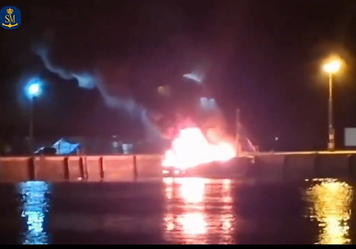 El barco pesquero ardiendo durante la pasada noche en el puerto de Camariñas (La Coruña)
