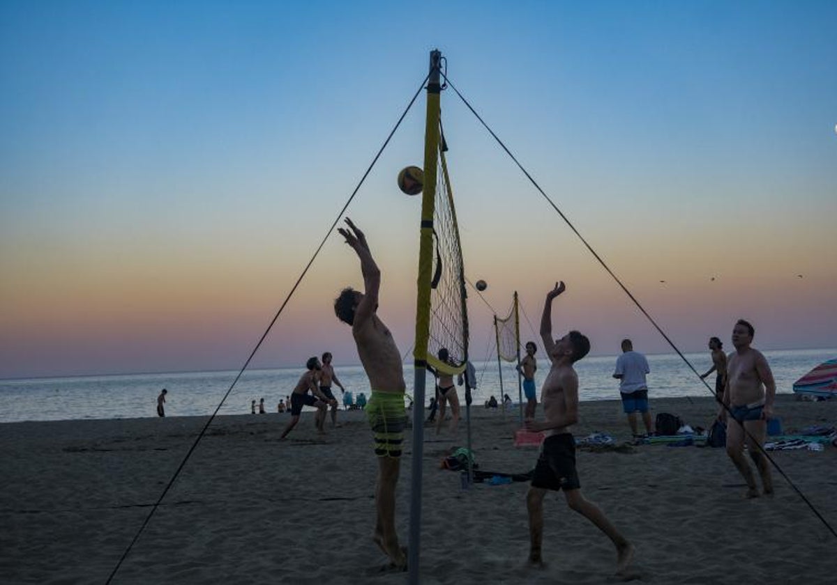 Varios jóvenes juegan en la playa