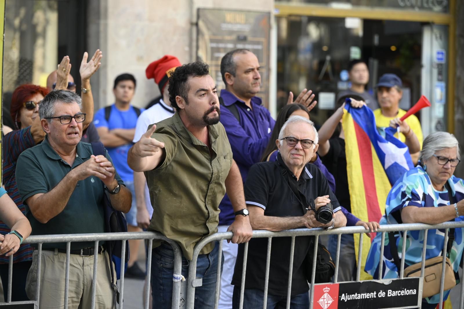 Varias personas entre el público increpan a los asistentes de la ofrenda floral 