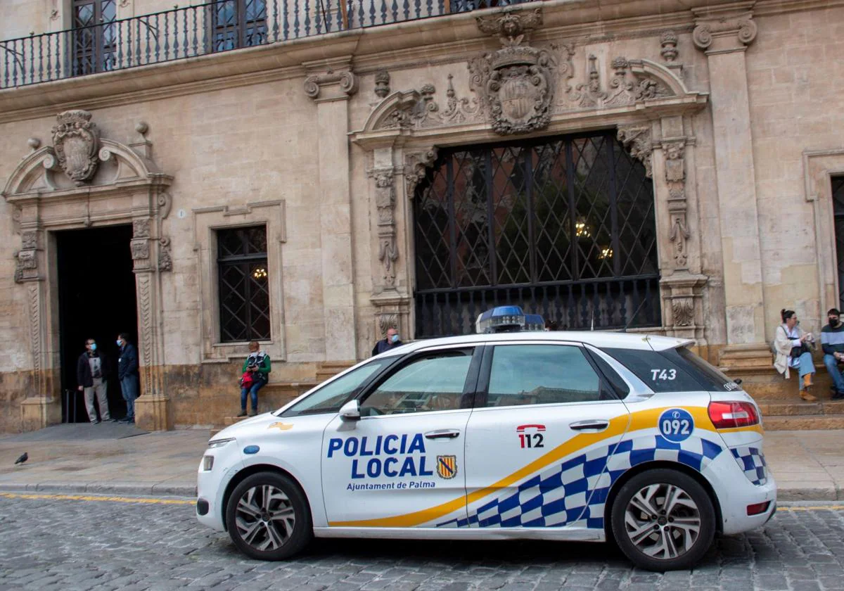 Un vehículo de la Policía Local circula frente al Ayuntamiento de Palma