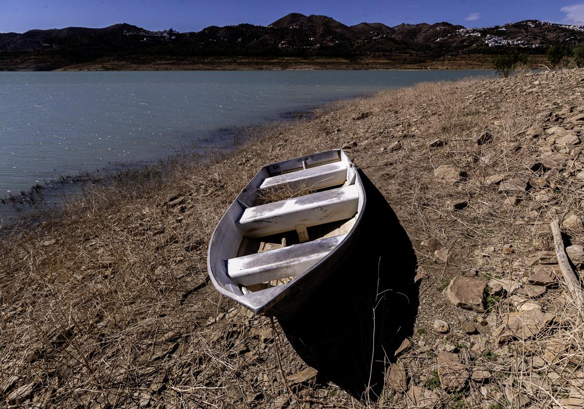 Una barca sobre la orilla seca del pantano de La Viñuela en Málaga