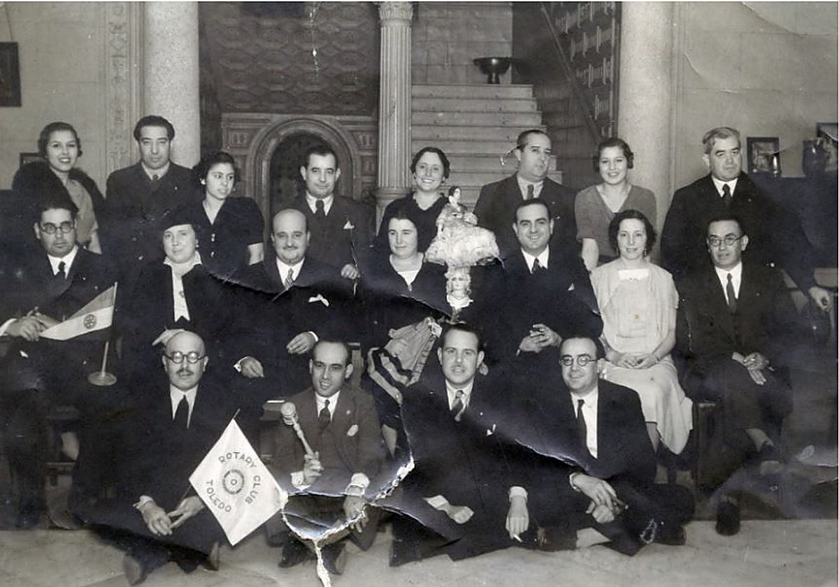 Miembros el 'Rotary Club de Toledo' posan con sus símbolos en el patio del Hotel Castilla, en 1932, para el fotógrafo Linares. Entre otras personas, Antonio Lillo, Diego Soldevilla, José Esteban Infantes, Wenceslao Manzaneque y Manuel Moro. En 1931, el Rotary Club de Alicante admitió a la primera mujer, no obstante, era habitual la participación femenina en los actos de muchos clubes. Archivo Municipal de Toledo. Colección Luis Alba