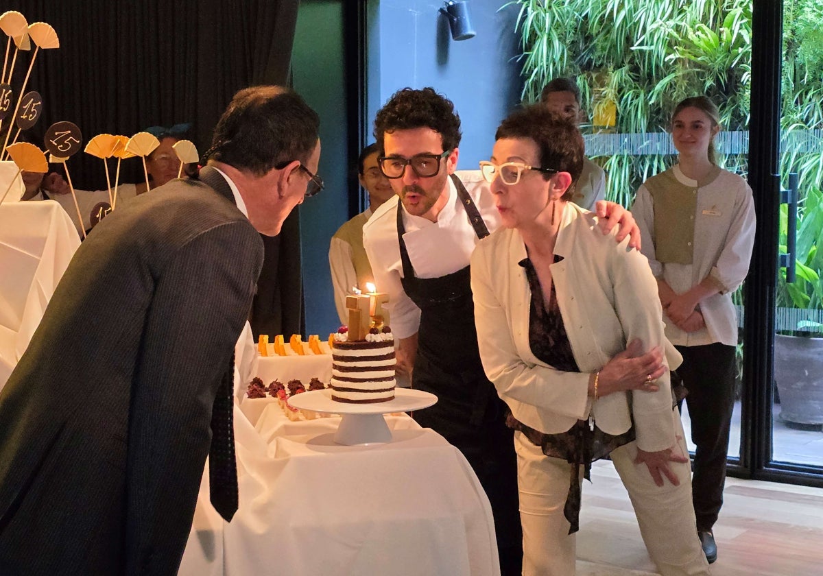 Carme Ruscadella y Toni Balam (de espaldas) soplan junto a su hijo Raül Balam las velas del 15 aniversario del restaurante Moments