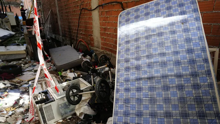 Callejón que lleva al patio trasero del edificio abandonado lleno de chatarra