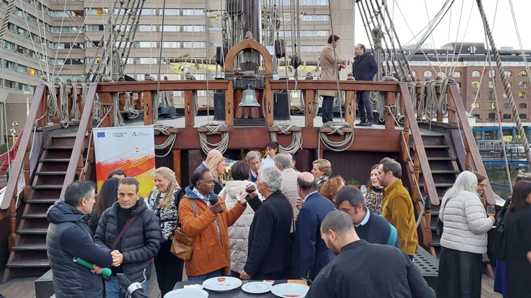 Varios invitados degustan productos andaluces sobre la cubierta del galeón