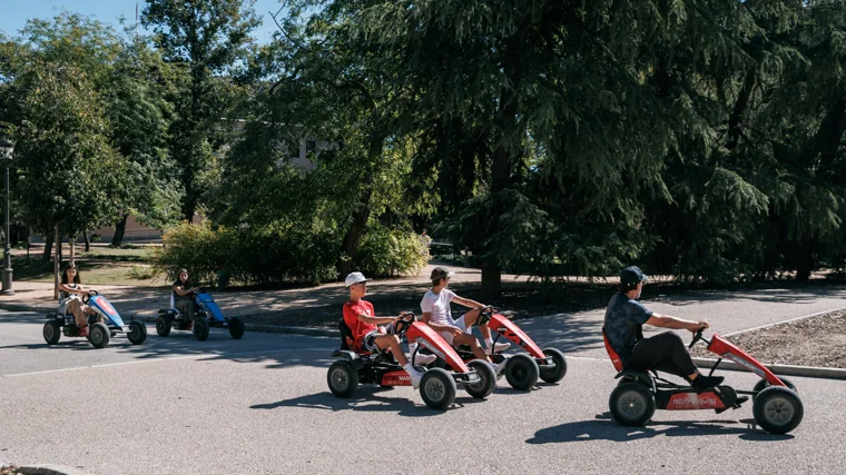 Varias personas conduciendo karts por el parque