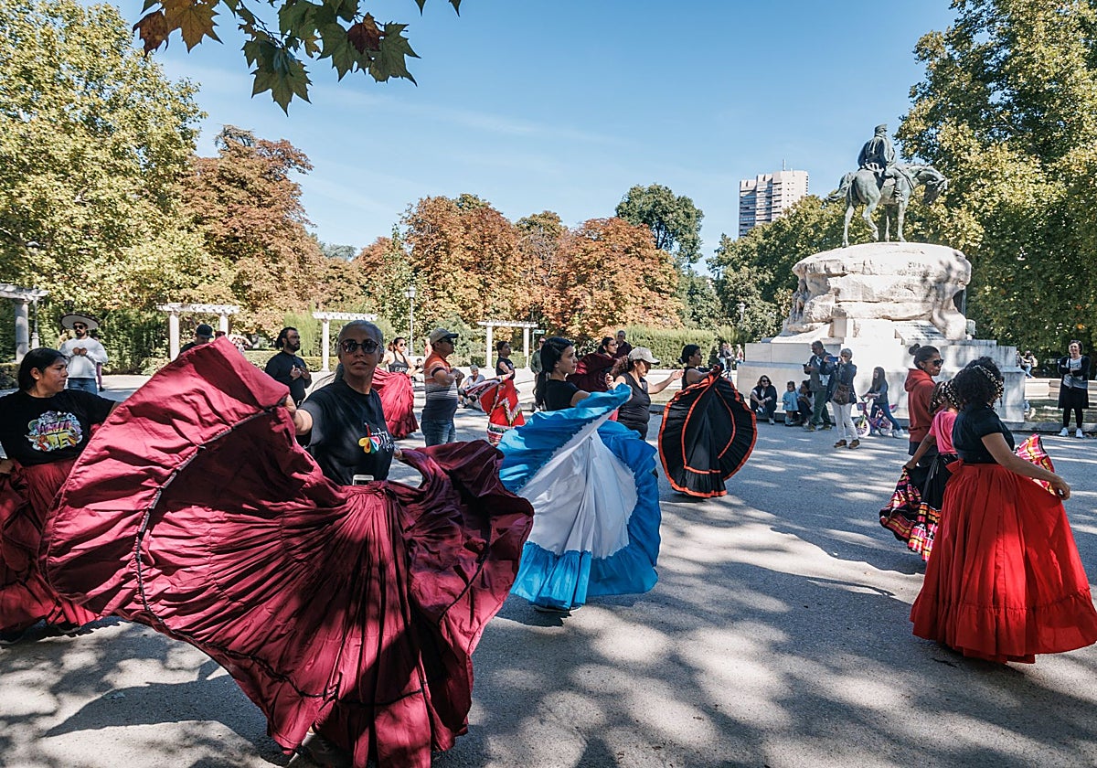 Varias personas bailan en el parque de El Retiro
