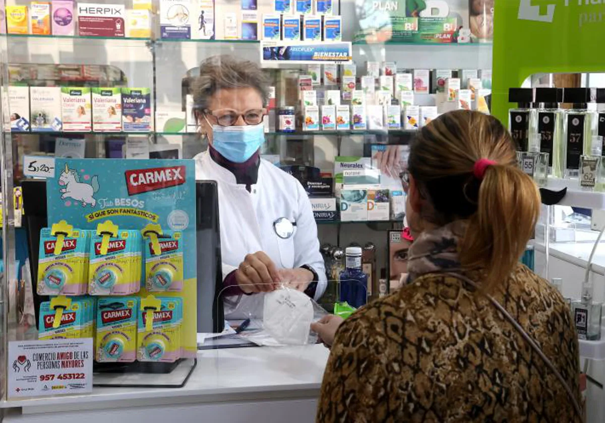 Una farmacéutica atiende a una cliente en un establecimiento de Córdoba